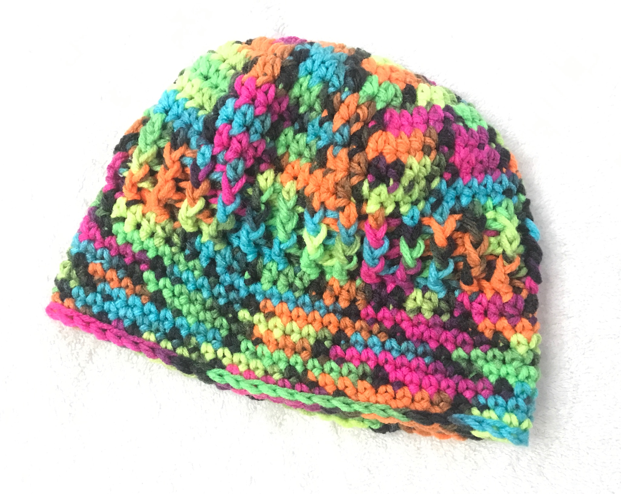 Don't you love the bright colors? What a fun way to use Red Heart Super Saver Blacklight Yarn for this crochet hat.